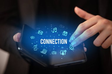 ConNECTION yazıtlı, sosyal medya kavramlı katlanabilir bir akıllı telefon tutan bir iş adamı