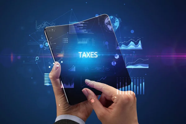 Empresário Segurando Smartphone Dobrável Com Inscrição Taxes Conceito Negócio Bem — Fotografia de Stock
