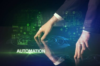 İş adamı, AUTOMATION yazıtları ve modern teknoloji konseptiyle büyük ekrana dokunuyor.