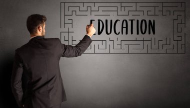 EDUCATION yazıtları ve iş eğitimi konseptiyle labirent çizen işadamı
