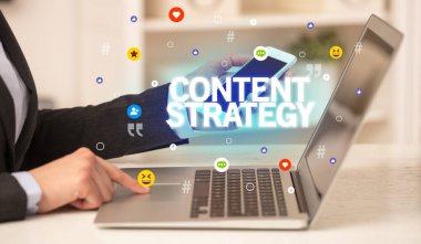 CONTENT STRATEGY yazıtlı, Sosyal medya konseptli dizüstü bilgisayar kullanan serbest çalışan kadın