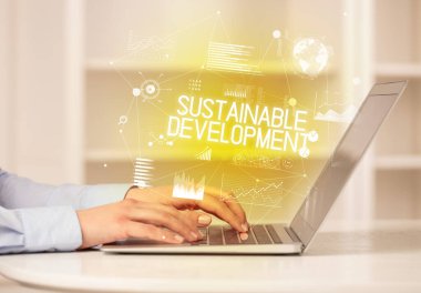 Diz üstü bilgisayarda çalışan bir iş adamının yan görünüşü SuSTAINable DEVELOPMENT yazıtları, modern iş konsepti