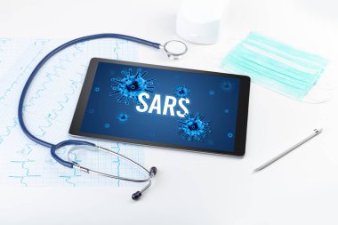 Beyaz yüzeyde SARS yazıtları, salgın konsepti olan tablet bilgisayar ve doktor araçları