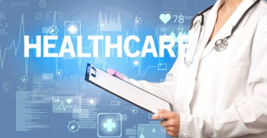 Genç doktor, sağlık hizmetleri konsepti ve sağlık sigortası yazısıyla notlar yazıyor.