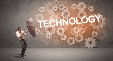 TECHNOLOGY yazıtlarından şemsiyeyle savunma yapan iş adamı, teknoloji kavramı