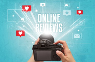 ONLINE REVIEWS yazıtları, sosyal medya kavramı ile fotoğraf çeken bir elin yakın çekimi