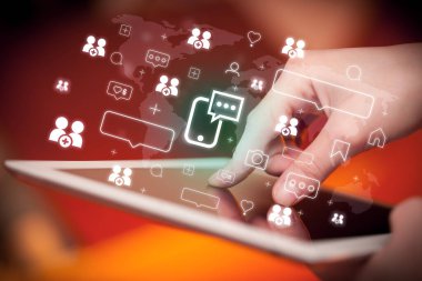 Akıllı telefon sohbet simgeleri içeren tablet kullanan bir elin yakın çekimi, sosyal medya kavramı