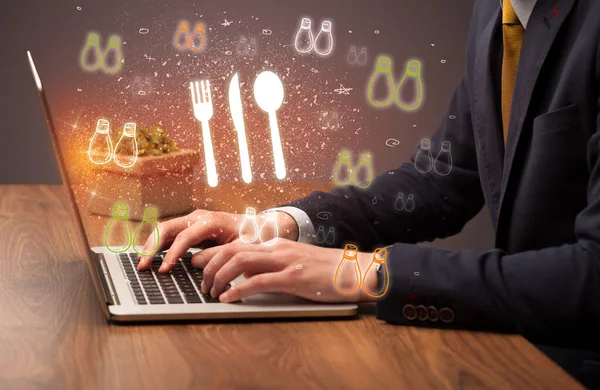 stock image Hand searching for recipes on the internet with chef hat icons coming out from the screen