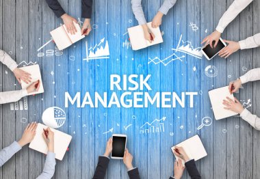 RISK MANAGEMENT yazıtları ve başarılı iş konseptiyle bir ofiste çalışan bir grup meşgul insan