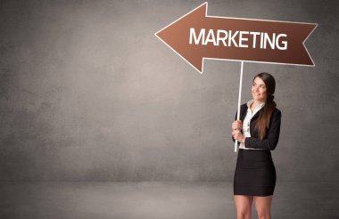 MARKETING yazıtları, iş yönü konsepti ile günlük bekleme yolu tabelasında genç iş adamı