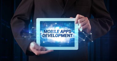 Tablet üzerinde çalışan genç iş adamı ve yazıyı gösteriyor: MOBILE APPS DEVELOPMENT
