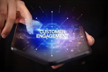 Müşteri Sözleşmesi ile birlikte katlanabilir bir akıllı telefon tutan bir iş adamı, yeni iş konsepti