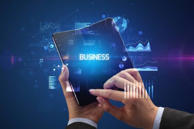 İş adamı elinde katlanabilir bir akıllı telefon tutuyor. İş dünyası yazıtları, başarılı bir iş konsepti.