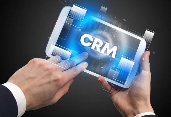 stock image Close-up of a hand holding tablet with CRM abbreviation, modern technology concept