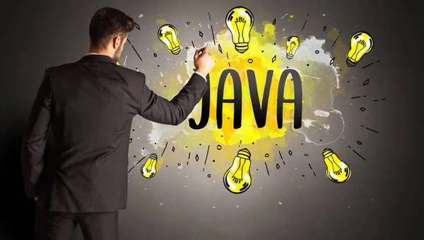 Stock image businessman drawing colorful light bulb with JAVA abbreviation, new technology idea concept