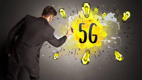 5Gの略語でカラフルな電球を描くビジネスマン 新しい技術のアイデアの概念 — ストック写真