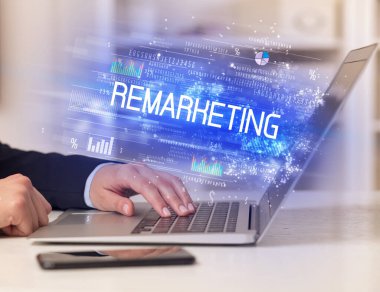 REMARKETING yazıtları, başarılı iş konsepti ile birlikte dizüstü bilgisayarda çalışan işadamlarının yakınlaşması