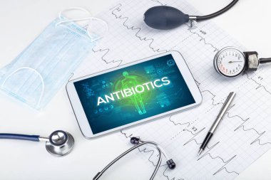 ANTIBIOTICS yazıt, koronavirüs kavramına sahip tablet pc ve doktor araçları