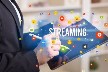 Sosyal medya simgeleri ve STREAMING yazıtları ile multimedya oynayan iş adamını kapat