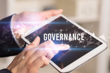GOVERNANCE yazıtları ve modern iş teknolojisi kavramı olan tablet kullanarak elleri kapat