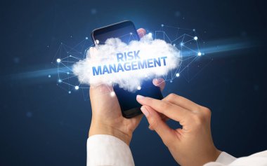 RISK MANAGEMENT yazıtlı akıllı telefona dokunan kadın el, bulut işi konsepti