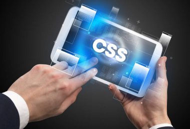 CSS kısaltmalı, modern teknoloji kavramlı el ele tutuşma tabletinin yakın çekimi