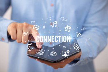 ConNECTION yazıtlı, sosyal medya kavramlı katlanabilir bir akıllı telefon tutan bir iş adamı