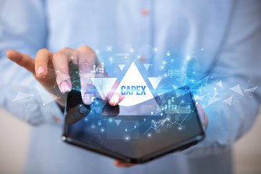 İş adamı CAPEX yazıtları ve iş konsepti içeren katlanabilir bir akıllı telefon tutuyor.