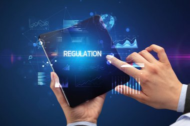 İş adamı katlanabilir bir akıllı telefon tutuyor. Üzerinde REGULAON yazıtları var. Başarılı bir iş konsepti.