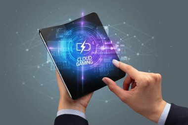 İş adamı elinde FUTURISTIC yazıtlı katlanabilir bir akıllı telefon tutuyor, yeni teknoloji kavramı CLOUD GAMING