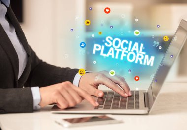 SOCIAL PLATFORM yazıtlı, Sosyal medya konseptli dizüstü bilgisayar kullanan serbest çalışan kadın
