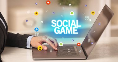 SOCIAL GAME yazıtlı dizüstü bilgisayar kullanan serbest çalışan kadın, sosyal medya kavramı