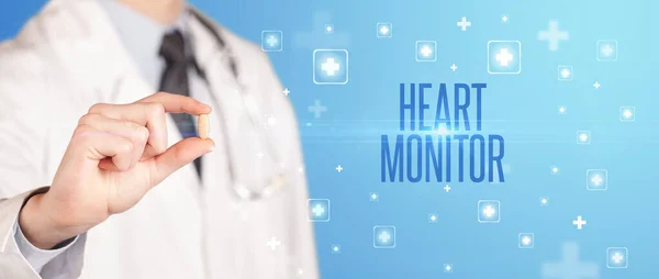 Zbliżenie Lekarza Dającego Tabletkę Napisem Heart Monitor Koncepcja Medyczna — Zdjęcie stockowe