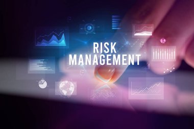 Tablete çizelgeler ve RISK MANAGEMENT yazıtları ile dokunmak, iş konsepti