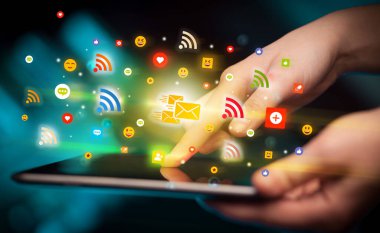 Renkli mesajlaşma simgeleri içeren tablet kullanan bir elin yakın plan görüntüsü, sosyal ağ konsepti
