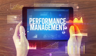 Performans Yönetimi yazılı tableti, modern iş konsepti olan ellerin yakın çekimi