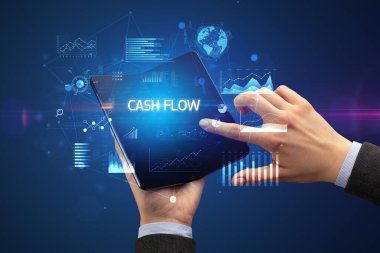 İş adamı, üzerinde Cash Flow yazan katlanabilir bir akıllı telefon tutuyor. Başarılı bir iş konsepti.