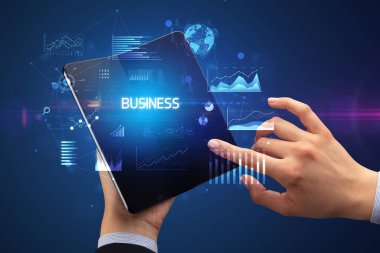 İş adamı elinde katlanabilir bir akıllı telefon tutuyor. İş dünyası yazıtları, başarılı bir iş konsepti.