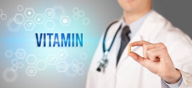 Doktorun sana VITAMIN yazıtlı bir hap verdiği yakın plan, tıbbi konsept.
