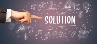 Kesilmiş ellerin yakın çekimi SOLUTION yazıtlarına işaret ediyor, modern iş çözümleri kavramı