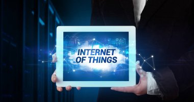 Tablet üzerinde çalışan genç iş adamı ve yazıtı gösteriyor: Nesnelerin İnterneti