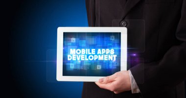 Tablet üzerinde çalışan genç iş adamı ve yazıyı gösteriyor: MOBILE APPS DEVELOPMENT