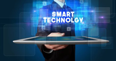 Tablet üzerinde çalışan genç iş adamı ve yazıyı gösteriyor: Akıllı TEKNOLJİ