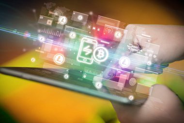 Bitcoin uygulama simgeleri içeren tablet kullanan bir elin yakın çekimi, dijital para birimi kavramı