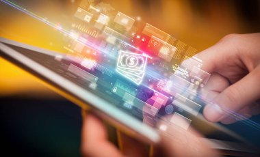 Bir elin, içinden nakit para ikonları çıkan tablet kullanılarak yakın plan fotoğrafı, dijital para birimi kavramı