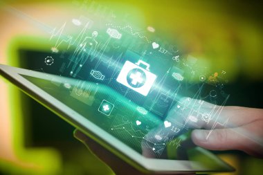 İlk yardım simgeleriyle, modern sağlık hizmetleri konseptiyle dokunmatik ekranın yakın çekimi