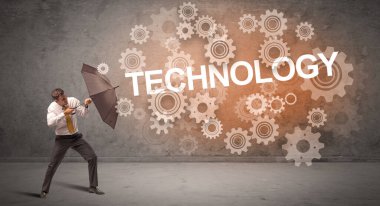 TECHNOLOGY yazıtlarından şemsiyeyle savunma yapan iş adamı, teknoloji kavramı