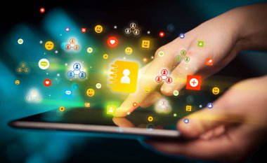 Renkli ajanda simgeleri içeren tablet kullanan bir elin kapatılması, sosyal ağ konsepti