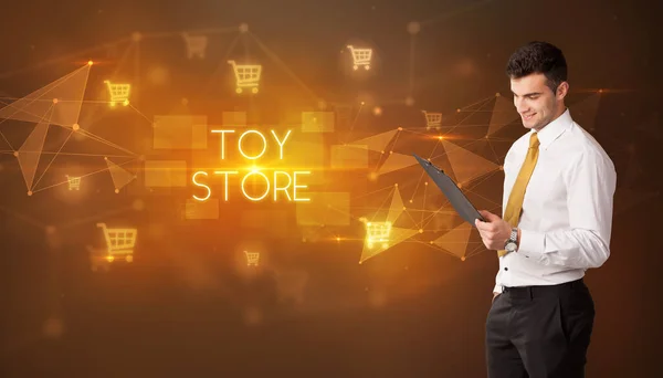 ショッピングカートのアイコンとおもちゃの店の碑文を持つビジネスマン オンラインショッピングコンセプト — ストック写真