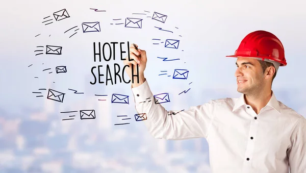 Handsome businessman with helmet drawing HOTEL SEARCH inscription, contruction sale concept